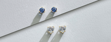 Two pairs of earrings: one with blue diamonds and the other with white diamonds, placed horizontally on a white background.