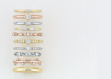 Five white gold bands placed next to each other, displayed on a white background.