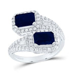 White gold diamond cuff ring featuring two emerald-cut blue sapphire stones on each end, accented with sparkling diamonds for a refined and elegant look