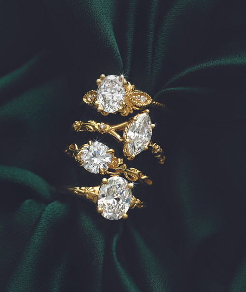 Four gold rings stacked on top of each other, displayed against a velvet green background.