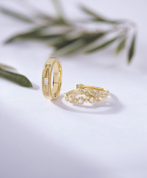 Three diamond bands: one tilted, two leaning on each other, against a white background with blurred green leaves in the distance