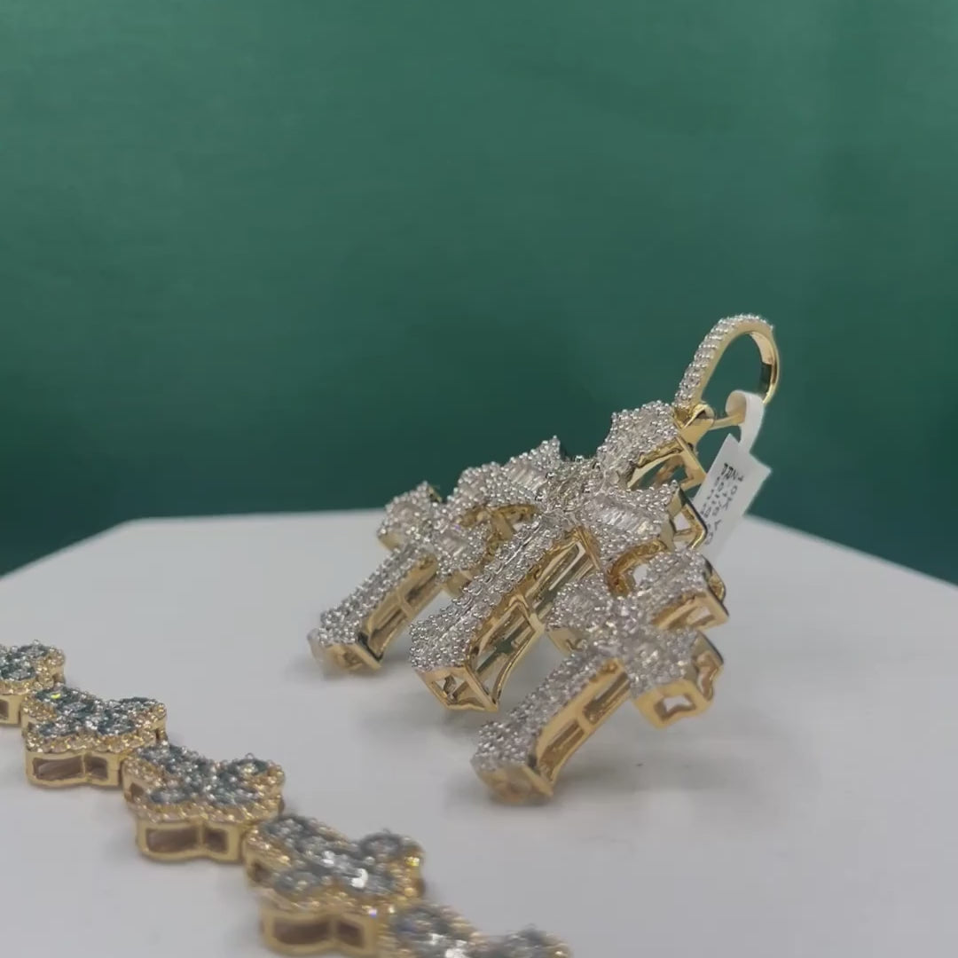 Three-cross diamond and gold pendants spinning on a white display with a teal background.
