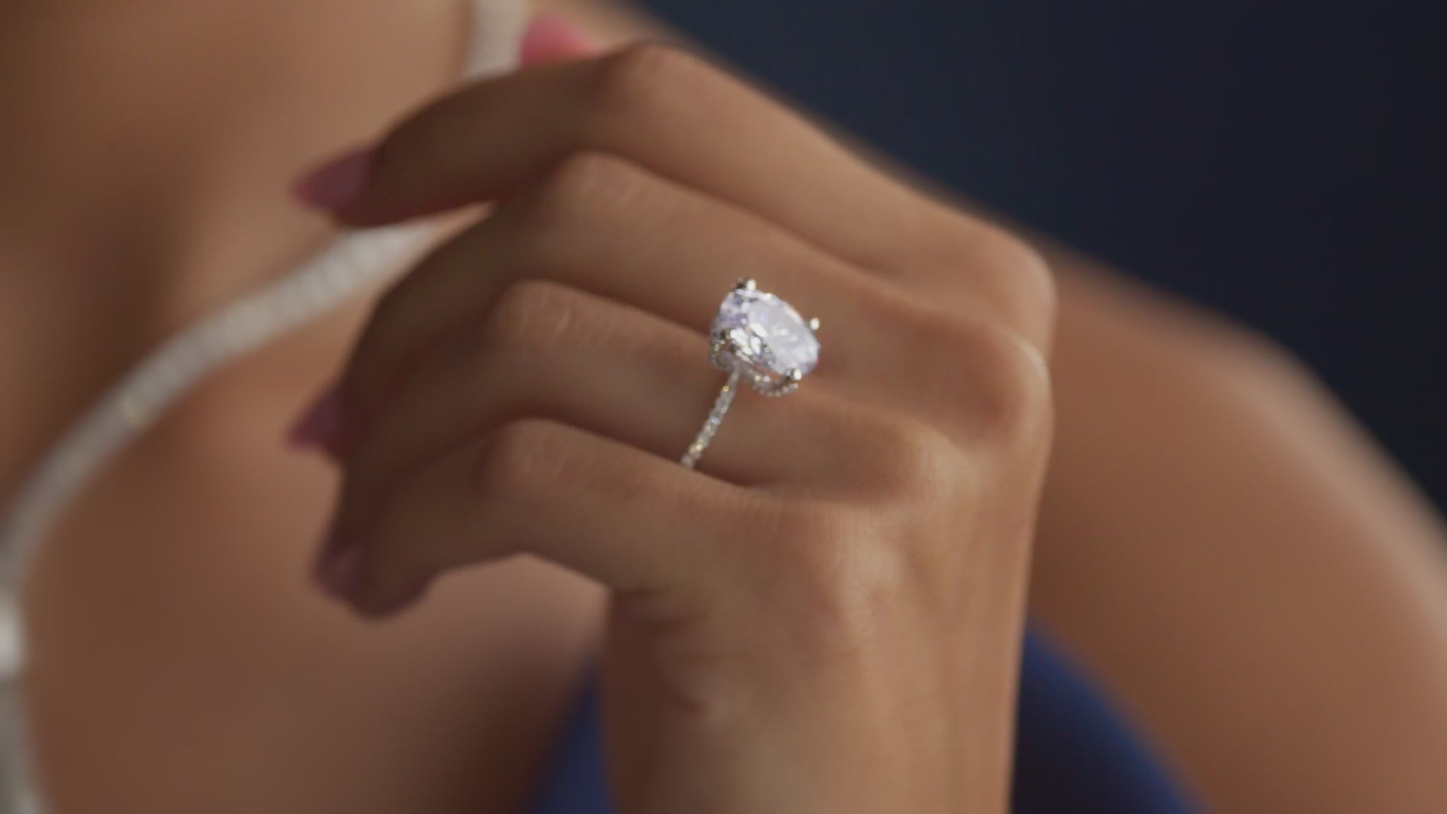 diamond ring on hand with diamond necklace on neck blurred out